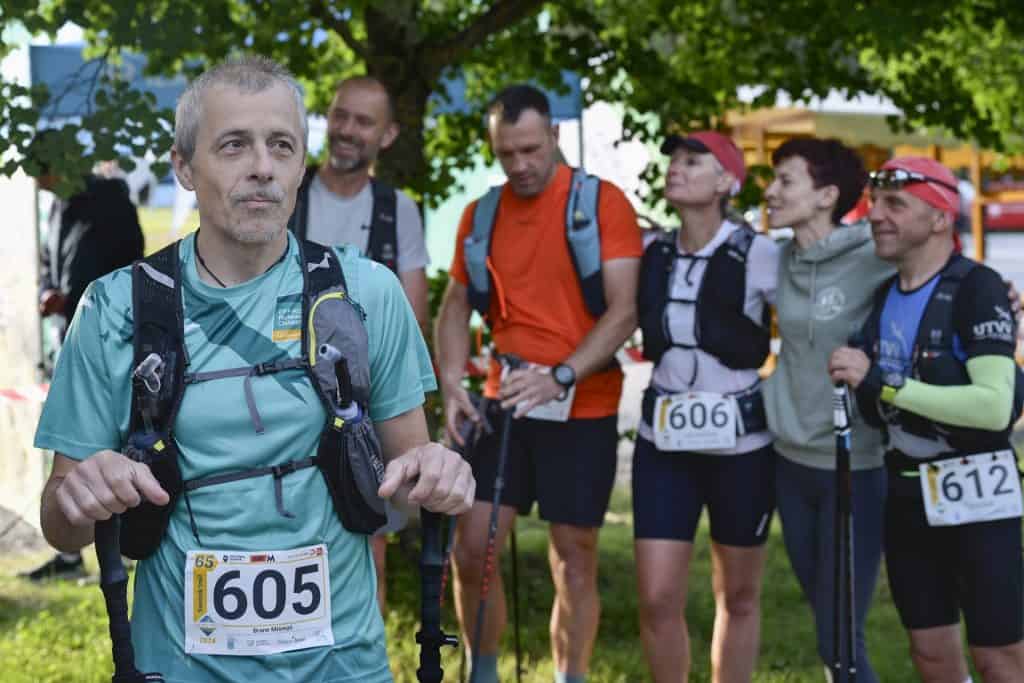 Udeleženci trail teka v naravi, pripravljeni na tek skozi gozd.